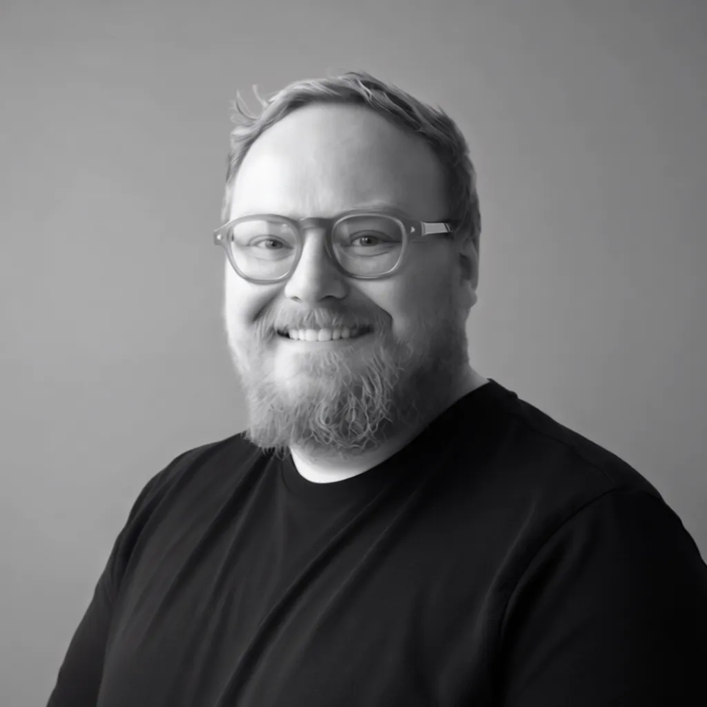 A headshot of Sam smiling, looking at the camera